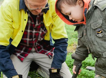 Image of a Parafield Airport worker and child planting a tree