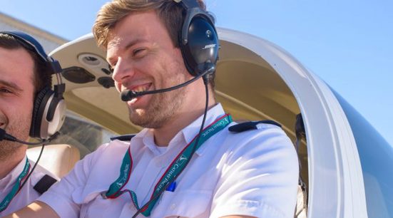 A pilot instructing another in a plane