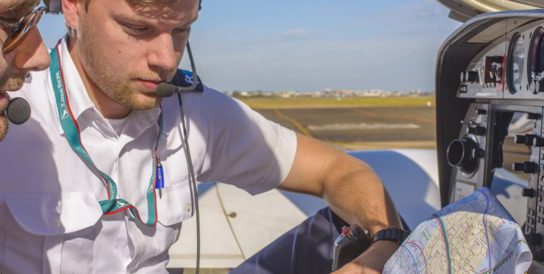 Two pilots looking at a map inside a jet