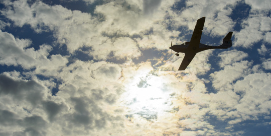 plane flying against clouds