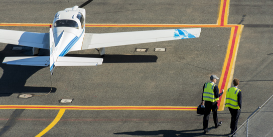 Plane wing and worker on tarmac