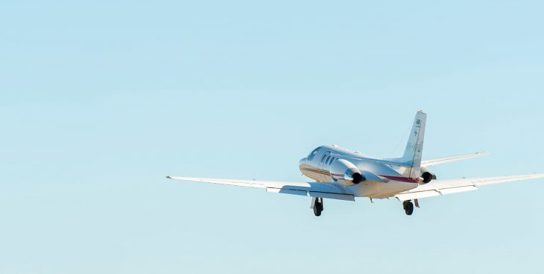 Image of small private jet flying in the sky