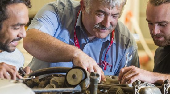 Three people working on an aircraft engine at Parafield Airport