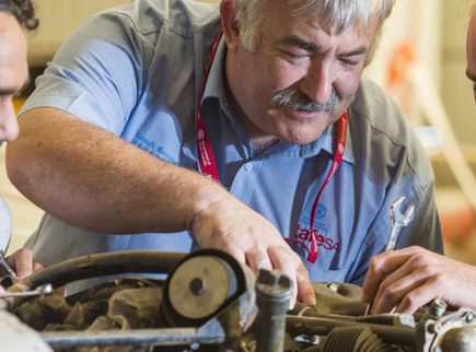 Image of people working on a plane engine